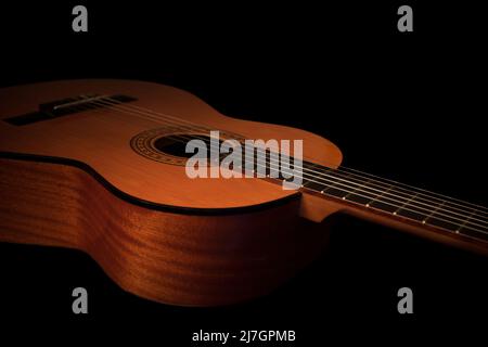 Acoustic Spanish classical guitar body close up on a black background. Stock Photo