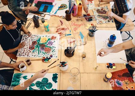 High angle view of students practicing painting at table in art class Stock Photo