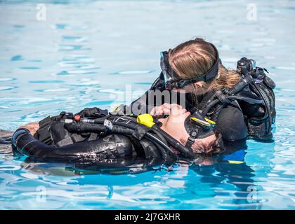 Scuba Diving rescue course surface skills checking for breathing of an unconscious diver Stock Photo