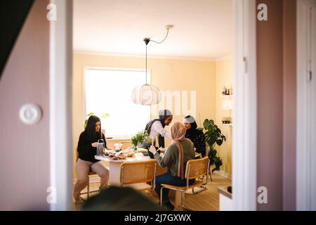 Young female friends preparing food together in kitchen at home Stock Photo