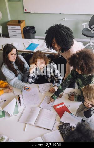 High angle view of teacher teaching diverse students in classroom Stock Photo