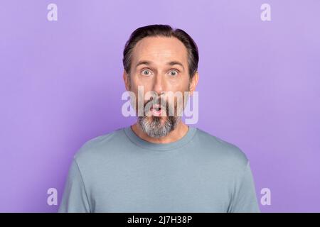 Portrait of amazed impressed male stare at camera see black friday bargain advertisement isolated on violet color background Stock Photo