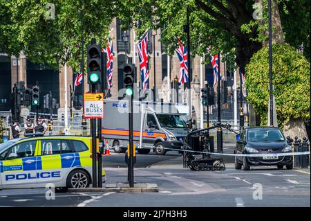 London, UK. 9th May, 2022. Police bomb squad officers use a robot to break a window and crack open the boot so that they can search a suspect car which is contained within a cordon outside Westminster Abbey. Credit: Guy Bell/Alamy Live News Stock Photo