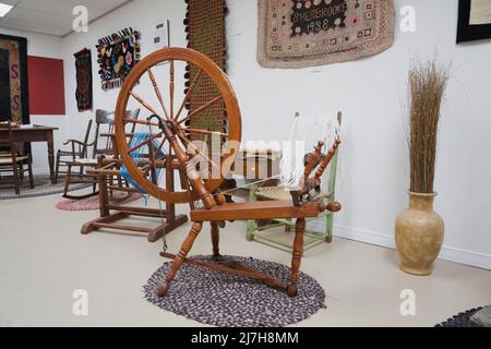 Antique spinning wheel and furnishings in room inside old 1790 Maison Rosalie-Cadron House Museum, Lavaltrie, Quebec, Canada. Stock Photo