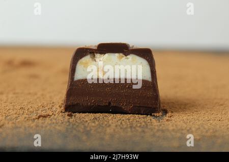 body chocolate candy with chocolate and white milk cream filling close-up  against the cocoa background. A day of chocolate sweets without diet.  handma Stock Photo - Alamy