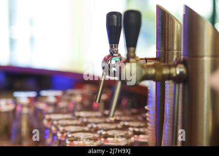 Close up of beer lines for draft beer in restaurant. Silver Cranes for pouring beer or wine in night club, bar or restaurant. Bartender workplace. Stock Photo