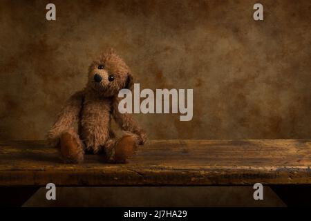 Retro handmade brown teddy bear on a rustic old wooden shelf. This is suitable for digital compositing. Stock Photo