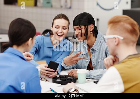 Diverse group of young people taking selfies while having fun in college Stock Photo