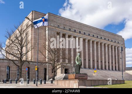 Finnish flag flying in front of Finnish parliament building in Helsinki Stock Photo