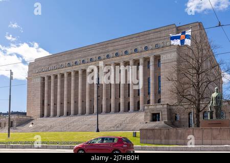 Finnish flag flying in front of Finnish parliament building in Helsinki Stock Photo