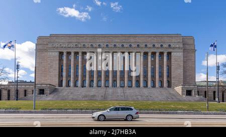 Finnish flag flying in front of Finnish parliament building in Helsinki Stock Photo