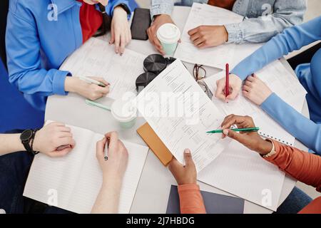 Top view of table with notebooks and documents busy group of college students preparing for exams Stock Photo