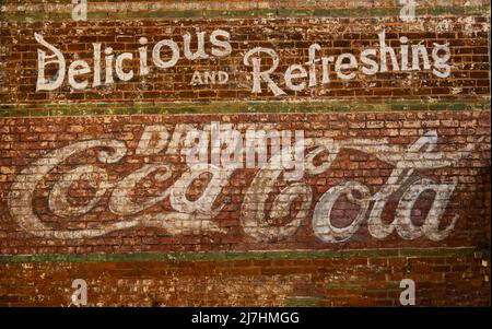 old painted Coco Cola sign on a red brick wall in Greenville SC Stock Photo