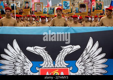 Moscow, Russia. 9th May, 2022. Young people carry Donetsk's People's Republic flag as they attend the Immortal Regiment march on Victory Day, which marks the 77th anniversary of the victory over Nazi Germany in World War Two, in central Moscow, Russia. Nikolay Vinokurov/Alamy Live News Stock Photo