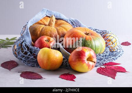 Pumpkins and apples in environmentally friendly reusable mesh bag Stock Photo