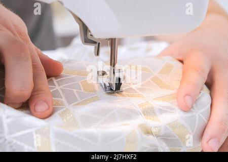 A man sews clothes on a sewing machine. Hobbies, needlework, creativity. Stock Photo