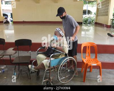 Manila, Philippines. 09th May, 2022. A woman with disability accompanied by her son arrives to cast her vote. 65.7 million Filipinos flock to their respective precincts to exercise their right of suffrage. They will cast their votes to decide who will be the next president. And they will also fill their ballots for executive and legislative posts for national, provincial and local levels. Credit: SOPA Images Limited/Alamy Live News Stock Photo