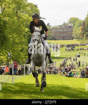 Badminton Horse Trials - Cross Country Test - Badminton, UK. 07th May, 2022. Richard Jones on Alfies Clover gallops with Badminton House in the background during the Cross Country Test at the Badminton Horse Trials. Picture Credit : Credit: Mark Pain/Alamy Live News Stock Photo