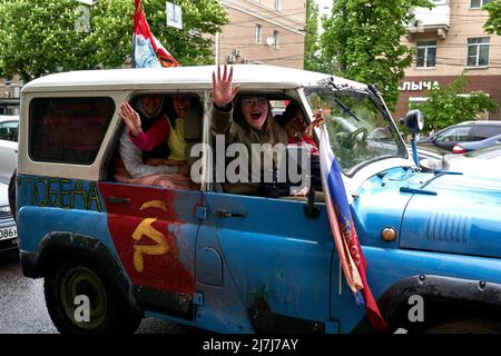 Participants of the rally in an old SUV with various patriotic symbols on the 77th anniversary of the Victory Day in Voronezh. Victory Day in Russia has long turned from a day of memory of the feat of the Soviet people into a day of oblivion, from a day of victory over Nazi aggression into a day of saber-rattling, from a day of the triumph of reason and progress into a day of obscurantism and idiocy. People dress up children in Soviet uniforms, arrange a carnival, get drunk, brandish various symbols: from communist to nationalist and monarchist. In 2022, the sign of the military invasion of Uk Stock Photo
