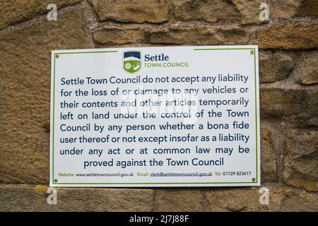 06.05.2022 Settle, North Yorkshire, Uk.Sign post in the centre of Settle in North Yorkshire advising theur policy on liability Stock Photo