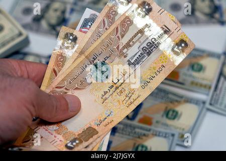 man hand holding a stack of United Arab Emirates 200 two hundred dirhams money, spending, giving and using money concept, paying and buying using bank Stock Photo