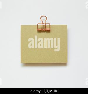 Green memo pad and metal clip isolated on white background. top view, copy space Stock Photo