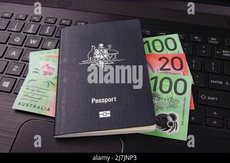 australian passport and bank notes on a black computer keyboard Stock Photo