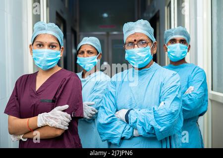 group of surgeons and practitioners confident standing with arms crossed by looking camera at hospital corridor - concept of healthcare and medical Stock Photo