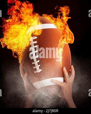 Child's hands with burning rugby ball on black background Stock Photo