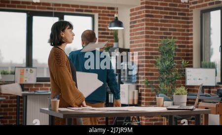 Workmates having argument about project planning, trying to work on business strategy. Aggressive man throwing papers in air and fighting with woman. Colleagues in conflict having dispute Stock Photo
