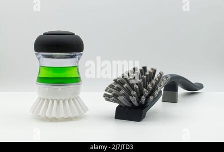 Dish brush cleaning tool with green liquid detergent and cleaning brush isolated on white background. Stock Photo