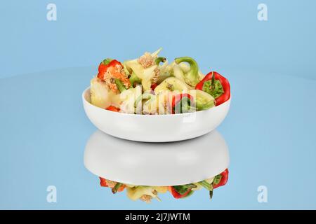 Bowl with fresh choped paprika, Bell Pepper, isolated on blue background. High resolution photo. Full depth of field. Stock Photo