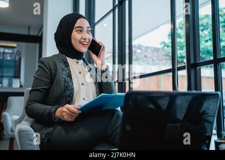 muslim businesswoman making a phone call while working in the office Stock Photo