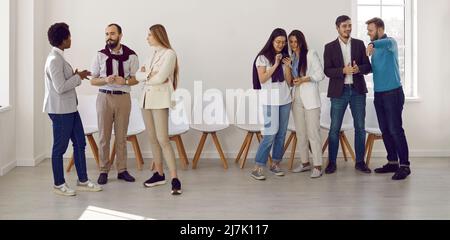 Groups of people communicate with each other while discussing presentation or business seminar. Stock Photo