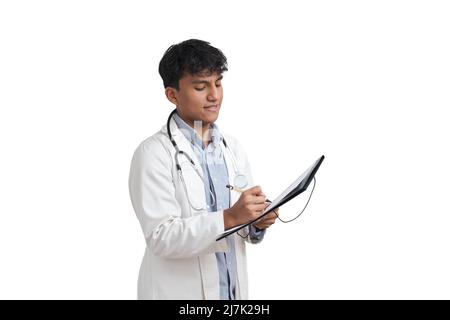 Young peruvian male doctor writing a medical report on a folder, isolated. Stock Photo