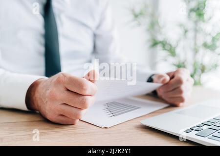 Businessman analyzing business results report in office, selective focus Stock Photo