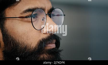 Close up profile face view portrait bearded thoughtful arabian boss entrepreneur business man in glasses indoor dreaming looking away lost in thoughts Stock Photo