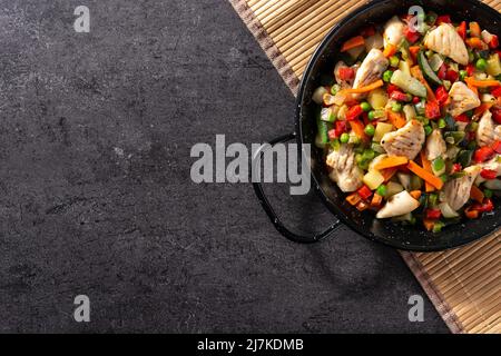 Chicken stir fry and vegetables on black stone Stock Photo