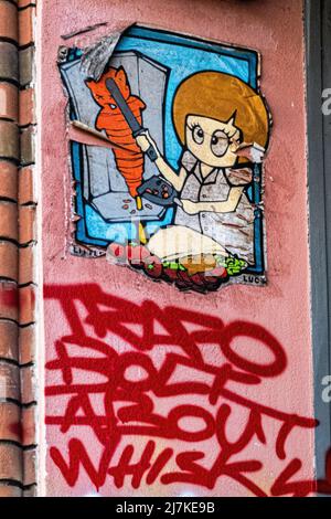 Graffiti and street art in Berlin - El Bocho's 'Little Lucy killing her cat' series In Danziger Strasse, Prenzlauer Berg, Berlin Stock Photo