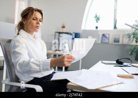 Business woman examines documents while sitting at the office workplace Stock Photo