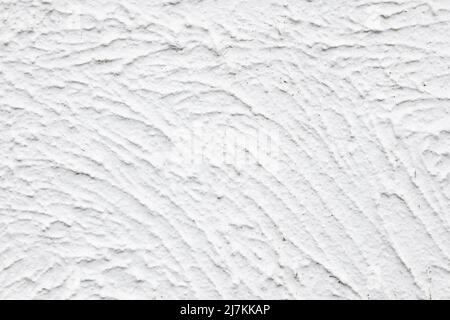 Closeup textured background of white uneven plaster wall outside building on town street in daytime Stock Photo