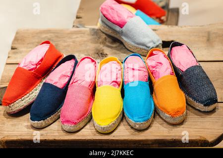 From above of various colorful rope soled comfortable espadrilles placed on wooden table in fashion boutique Stock Photo