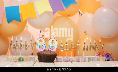 Happy birthday to a child from golden letters of burning candles on the background of my balloons. Beautiful birthday card Stock Photo