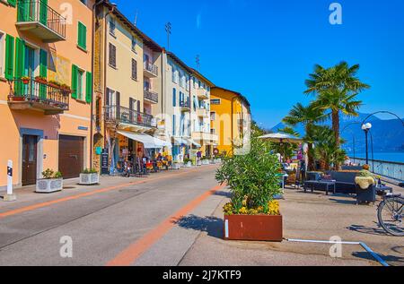 MORCOTE, SWITZERLAND - MARCH 25, 2022: Explore picturesque embankment of Lake Lugano with line of colorful historic houses, on March 25 in Morcote Stock Photo