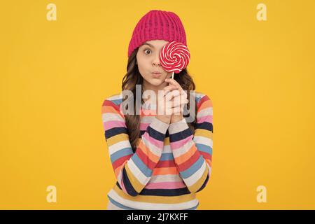 surprised teen girl hold lollipop. lollipop lady. hipster kid with colorful lollypop sugar candy Stock Photo