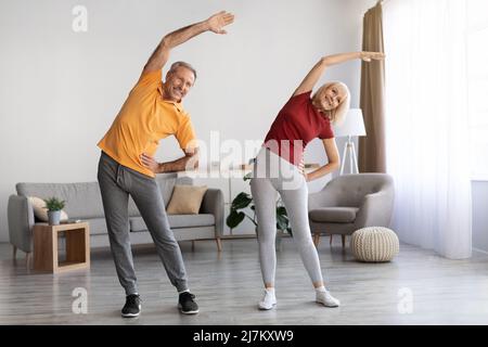 Positive mature couple having workout at home Stock Photo