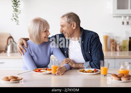 Loving senior husband and wife having breakfast together Stock Photo