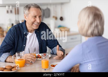 Cheerful senior man having breakfast with his wife Stock Photo