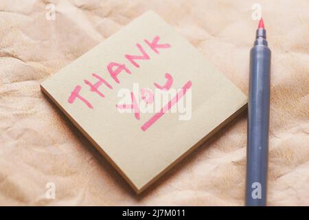 thank you message on a sticky note on old paper  Stock Photo