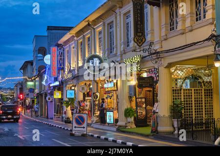 Dusk falls on the beautifully restored old Sino-Portuguese shophouses and restaurants in Thalang Road in the Old Town area of Phuket Town, Thailand Stock Photo